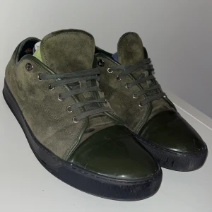 Lanvins - Snygga gröna  sneakers från lanvin  och glansig tå. Skorna har en stilren design med mocka och syntetmaterial. Perfekta för en trendig look. Medföljer ingen låda därav pris. Liten skråma på captoen Nypris ca 5300 just för denna färg är sällsynt OBS: skorna har hål i hälen på varsin fot! 
