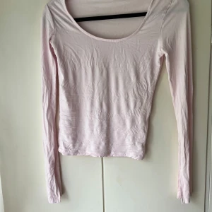 Ljusrosa långärmad topp - Säljer en ljusrosa långärmad topp med rund halsringning. Enkel och stilren design som passar perfekt till jeans eller kjol. Mjuk och skön att ha på sig. Säljer den helt oanvänd