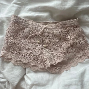 Ljusrosa spetsshorts H&M 🩷 - Supersöta ljusrosa virkade shorts från H&M Conscious Collection med blommigt spetsmönster och snörning i midjan. Perfekta för sommarens varma dagar och festivaler. Storlek XS. Bra skick.