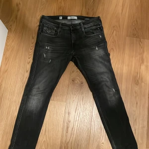 Replay svarta skinny jeans med slitningar - Säljer ett par feta grå jeans från Replay i storlek W32 och L32. Jeansen har skinny passform och coola slitningar framtill. Jeansen har fem fickor, dragkedjegylf och tydliga Replay-detaljer på vänster ficka. Materialet är stretchigt jeans för en bekväm känsla och de har en något tvättad look. Köpte dem för ett par månader sedan men knappt använt då jag tycker att dem är för långa för mig. Köpte dem nya för 1600kr och säljer för 599kr. Pris kan diskuteras!