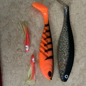 Fiskedrag och jiggar - set med 4 st - Ett set med fyra fiskedrag och jiggar i olika färger och former. Perfekt för dig som gillar fiske och vill testa olika beten för att locka till dig stora fångster. Helt oanvända. Sälj pga att dem är för stora för mitt spö. Pris kan diskuteras