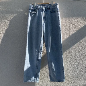 Ljusblå raka jeans från Karve - Säljer ett par ljusblå jeans från Karve med bred passform och klassisk femficksdesign. Jeansen har normal midja, dragkedja och är tillverkade i 100% återvunnen bomull. Storlek 29.