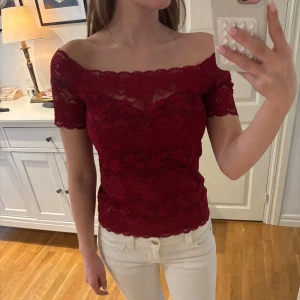Spetstopp - Vinröd spetstopp i offshoulder-modell. Perfekt för dig som vill ha en romantisk och trendig look. Lappen är bortklippt, men skulle säga att den sitter som en S/M. Jag är 162, och den sitter perfekt på mig.