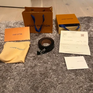 Svart Louis Vuitton bälte  - Säljer ett svart bälte, bältet är 115 cm långt och är som nytt har använt de typ 3 gånger de  Kommer med originalpåse, box och kvitto och kort allt og. Om du har några frågor eller funderingar är de bara att höra av sig!🤩