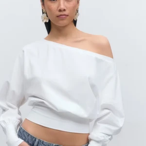 Vit oneshoulder topp - Snygg vit oneshoulder topp med lång ärm och bred resår i midjan. Perfekt för dig som vill ha en stilren och trendig look. Passar till både jeans och kjol.