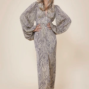 Zebramönstrad långklänning med knappar - långklänning med zebramönster och knappar framtill. Helt ny och lappen är till och med kvar!🥰