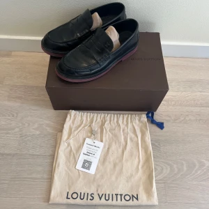 Svarta loafers från Louis Vuitton - Snygga svarta loafers från Louis Vuitton i skinn. Skorna har en klassisk design med märkets logotyp diskret placerad på ovansidan. Kommer med dust bag, kartong och äkthetsbevis!