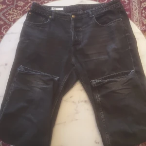 Svarta jeans från Zara - Snygga svarta jeans från Zara med klassisk femficksdesign och knappgylf. Perfekta för en stilren look. Tillverkade i Bangladesh.