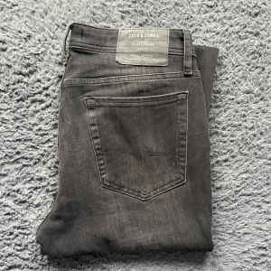 Jack & Jones jeans  - Snygga grå skinny jeans från Jack & Jones. De har en klassisk femficksdesign och är tillverkade i ett stretchigt material för en bekväm passform. Perfekta för en stilren look. Tyvärr kan jag inte skicka bild när jag själv bär plagget då jag för det första ofta inte kan ha storlekarna jag säljer och för det andra skulle det bli alldeles för mycket jobb när jag säljer så mycket, så jag rekommenderar att man kikar måtten på sista bilden heller googlar på modellnamnet för att se passformen :)