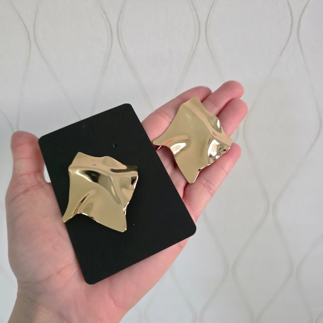 Stora guldörhängen i abstrakt design