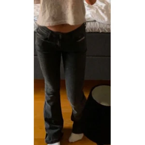 Svarta bootcut jeans - Snygga svarta bootcut jeans med låg midja. Perfekta för en avslappnad stil. De har en klassisk design med dragkedja och knappar framtill. Storlek xxs i short