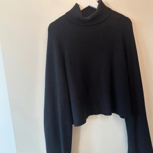 Svart ribbad polotröja från Bik Bok - Säljer en svart ribbad polotröja från Bik Bok. Tröjan har en croppad design och långa ärmar.