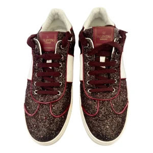 Glittriga sneakers från Valentino - Snygga glittriga sneakers från Valentino i vinrött och vitt. Skorna har snörning och en stilren design med glittriga detaljer som ger en extra touch. Perfekta för att lyfta vilken outfit som helst. Köpta på Vestiaire Collective för ca 6 månader sedan! Pris kan diskuteras såklart. 