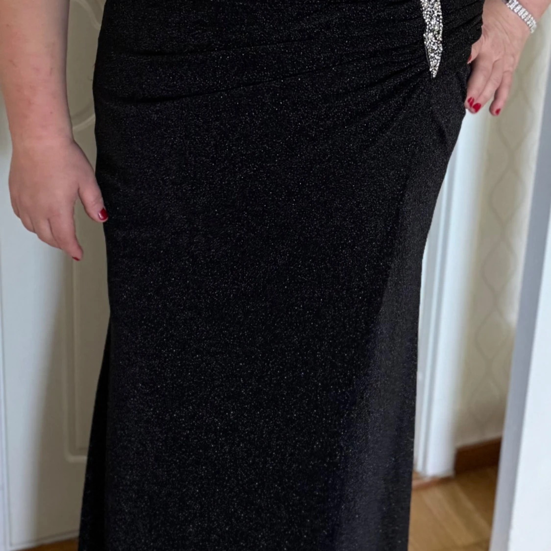 Svart glittrig långklänning med dekorativ detalj - 2