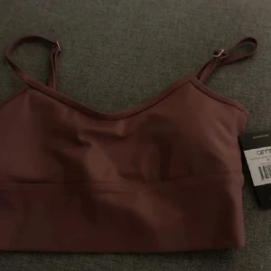 Brun linnetopp från Aim'n - Säljer en brun linnetopp från Aim'n med smala justerbara axelband. Toppen har en enkel och stilren design, perfekt för att matcha med  träningsbyxor som säljes också bland mina annonser 