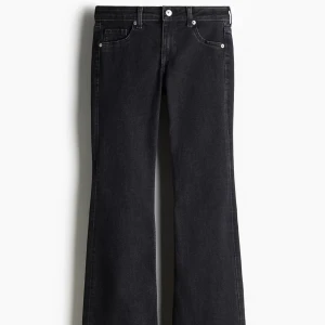 Svarta bootcut jeans H&M strl 36 - Svarta flare jeans från H&M med låg midja i storlek 36. Klassisk femficksmodell med dragkedja och knapp framtill. OBS:Jeansen är uppsydda.