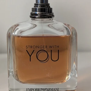 Emporio Armani Stronger With You parfym - Ca 80-85 ml kvar                                                  Emporio Armani Stronger With You är en parfym i en stilren, fyrkantig glasflaska med metallisk silverfärgad spraykork. Doften har en varm bärnstensfärgad vätska och flaskan har tydlig logga framtill. Perfekt för dig som gillar exklusiva och moderna dofter.