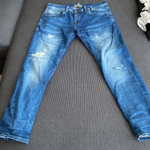 Blå skinny jeans från LTB - Säljer ett par blå skinny jeans från LTB med slitna detaljer och snygg tvätt. Jeansen har klassisk femficksdesign, normal midja och smal passform hela vägen ner. Perfekta för dig som gillar en modern och avslappnad look.