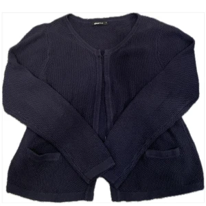 Marinblå stickad kofta från Gina Tricot - Marinblå stickad kofta från Gina Tricot i storlek M. Med långa ärmar, två fickor framtill och stängs med små krokar. 