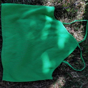 Grön ribbad linnetopp med smala band - Snygg grön ribbad linnetopp med smala axelband. Toppen har en enkel och stilren design som gör den lätt att matcha med olika outfits. Perfekt för varma dagar och ger en fräsch vibe till din look.