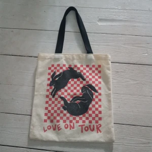 Harry Styles Love On Tour tote bag - Harry Styles Love On Tour tygkasse köpt på Camden market i London. Framsidan och baksidan har ett röd-rutigt mönster och två svarta kaniner samt texten 'Love On Tour'.