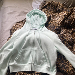 Ljus mintgrön hoodie från FB Sister - Säljer en ljus mintgrön hoodie från FB Sister i storlek M. Tröjan har dragkedja framtill, snörning i huvan och en croppad passform. Tillverkad i mjuk bomullsmix och har två stora fickor framtill. Perfekt för chill dagar eller när du vill vara extra comfy.