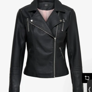 Svart skinnjacka från ONLY - Säljer en svart skinnjacka från ONLY med klassisk bikerstil. Jackan har sned dragkedja, dekorativa dragkedjor på bröst och sidor samt detaljerade sömmar på axlar och ärmar. Perfekt för en cool och tidlös look.
