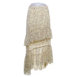 Blommig volangkjol  - Supersöt långkjol i ljusgul med blommigt mönster och volangdetaljer. Kjolen har asymmetrisk nederkant och resår i midjan för en bekväm passform. Perfekt för dig som gillar romantisk och bohemisk stil.