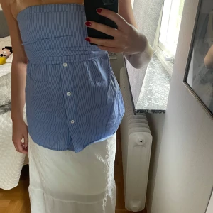 Blåvit randig tubtopp med knappar - Säljer en blåvit randig tubtopp med knappar framtill.. Perfekt för varma dagar och enkel att styla med kjol eller jeans💕