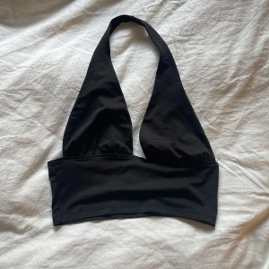 Svart halterneck topp - Säljer en svart halterneck topp med bred resår under bysten. Använd någon enstaka gång, så gott som ny💕