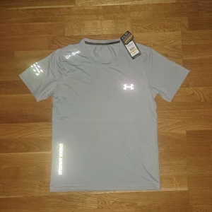 Under Armour Tröja - ✨ Grå färg som glänser med flash. ✅ Nytt skick, Tags kvar.  ⚡ Perfekt för träning eller vardag.