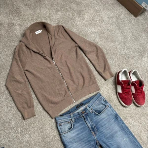 Beige ribbad kofta med dragkedja från East West - Säljer en beige ribbad kofta från East West med hel dragkedja framtill. Storlek M, köp för endast 399.