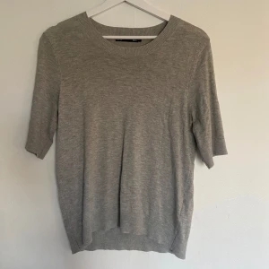 Ljusgrå stickad tröja från 157 - Säljer en ljusgrå stickad tröja från 157 i storlek S. Tröjan har rund halsringning och korta ärmar, perfekt för lager-på-lager eller som den är. Enkel och stilren design som passar till det mesta.