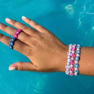 Färgglada pärlarmband och ringar med blommor - Säljer handgjorda armband och ringar av pärlor i olika färger med söta blommönster. Finns i blått, rosa, lila, vitt, grönt och fler färger. Perfekta accessoarer för att piffa upp din stil med en lekfull och trendig touch🩷priser mellan 20-35kr☀️