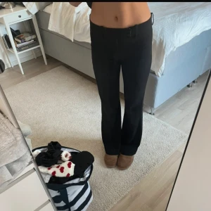 Svarta kostymbyxor från Zara - Säljer ett par svarta kostymbyxor från ARKET med klassisk passform och raka ben. Byxorna har hällor för bälte, diskreta bakfickor och stängs med dragkedja och knapp. Perfekta för en stilren look.