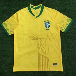 Brasilien fotbollströja gul - Gul Brasilien fotbollströja med gröna detaljer och mönster på ärmarna. Stort tryck av Kristusstatyn på både fram- och baksida samt Brasilien-emblem med stjärnor på bröstet. Klassisk V-ringning med grönt kantband.