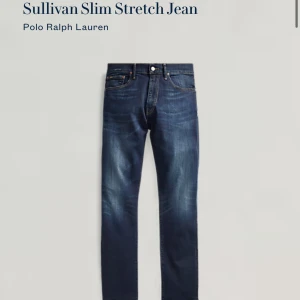 Sullivan Slim Stretch Jeans från Polo Ralph Lauren - Mörkblå jeans från Polo Ralph Lauren i modellen Sullivan Slim Stretch och storlek 31/32. Klassisk femficksdesign, smal passform och stretchigt denimtyg för extra komfort. Snygga slitningar och diskreta kontrastsömmar. Perfekta för en stilren look. Knappast använda, och nypris ligger runt 1699kr!