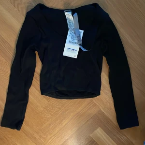 Svart långärmad topp från Zara - Säljer en svart långärmad topp från Zara med v-ringning. Toppen är tight i modellen och passar perfekt till många olika outfits. Enkel och stilren design som är lätt att matcha.