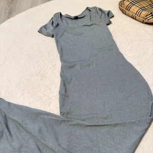 Ljusgrå ribbad långklänning från SHEIN - Säljer en ljusgrå ribbad långklänning från SHEIN med korta ärmar och rund halsringning. Klänningen har en tight passform och är perfekt för dig som gillar en enkel men stilren look.