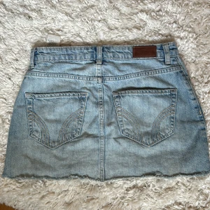 Ljusblå jeanskjol från Hollister - Säljer en ljusblå jeanskjol från Hollister i storlek 26 passar xs-s med klassisk design på bakfickorna. Kjolen är kort och är perfekt nu till sommaren och går att matcha till alla möjliga toppar! Jag säljer kjolen då den är för liten💞