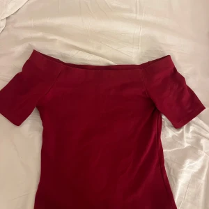 Mörkröd offshoulder topp - Säljer en mörkröd offshoulder topp från hm. Den är knappt använd och är i jättebra skick. priset går att diskutera!🩷