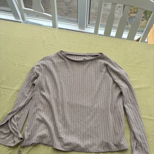 Beige ribbad tröja - Säljer en stilren beige ribbad tröja med långa ärmar. Perfekt för en avslappnad look. Tröjan har en mjuk och bekväm passform. Den har slits i slutet av armar och i nederkant på tröjan💕🌸💕🌸så fin!!