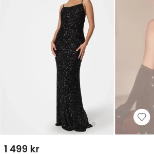 Svart glittrig långklänning - Elegant svart balklänning med glittrande detaljer och smala axelband. Klänningen har en öppen rygg med snörning.