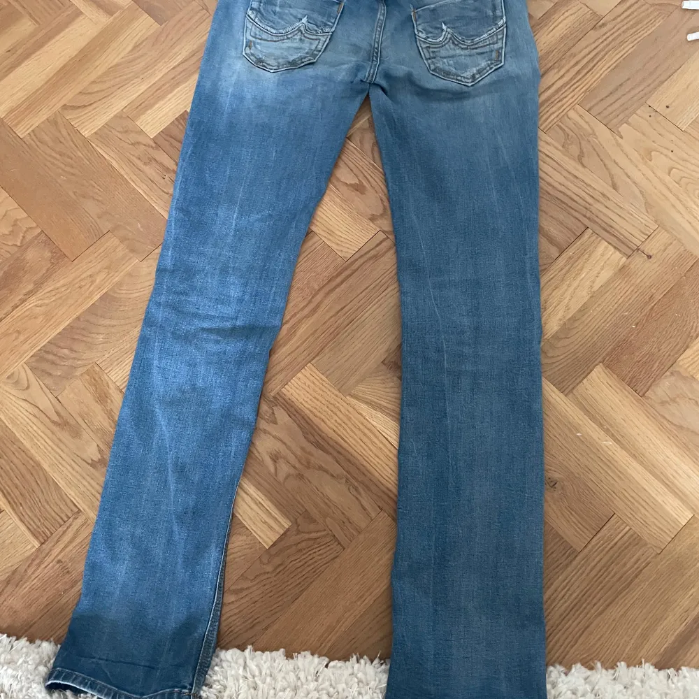 Blå jeans som har lite bootcut(blir mer med skor). Är lite insydda men fortfarande 27 i storlek(dock ganska små). Säljer då de är för stora och därmed inte används. Är 170 men skulle nog fortfarande passa för lite längre. Skriv privat för fler bilder och mått! Pris kan diskuteras!. Farkut & Housut.