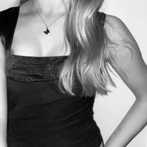 fest topp - Snygg svart topp med satin detaljer. Perfekt för en kväll ute eller en speciell tillställning. Toppen har en elegant design som framhäver axlar, bröst och nyckelben