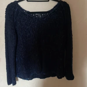 Mörkblå stickad tröja från Gina Tricot - Säljer en mörkblå stickad tröja från Gina Tricot. Tröjan har en rund halsringning och långa ärmar. Perfekt för kyligare dagar. Passar bra till jeans eller kjol.