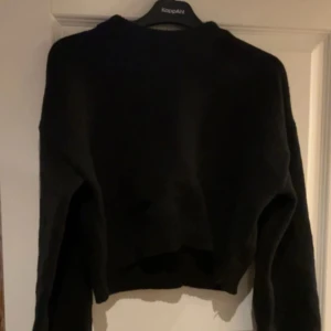 Svart stickad tröja - Säljer en svart stickad tröja med långa ärmar. Perfekt för kyligare dagar och enkel att matcha med olika outfits. Tröjan har en klassisk design och är ett måste i garderoben.