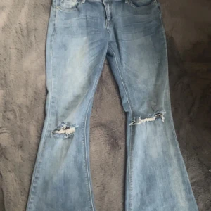 Jeans - Jeansen är bootcut och har hål vid knäna, Passar runt M-L då jag upplever de mindre i storleken. De är lådmidjade och har en fin passform. Sälja för jag tycker de har blivit lite förstora på mig. 