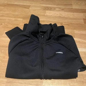 Svart träningsjacka från Stronger - Säljer en svart träningsjacka från Stronger med dragkedja 