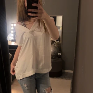 Vit ärmlös blus från H&M  - Säljer en stilren vit ärmlös blus med v-ringning. Tröjan har inga defekter och används tyvärr inte. 